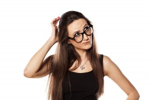 unsure young woman scratching her head